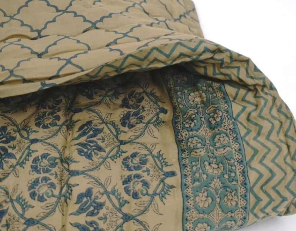 Folded organic cotton quilt showing block printed repeat | Myyra Jaipur