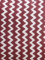 Close-up of maroon zigzag hand block print on organic cotton cushion cover | Myyra Jaipur